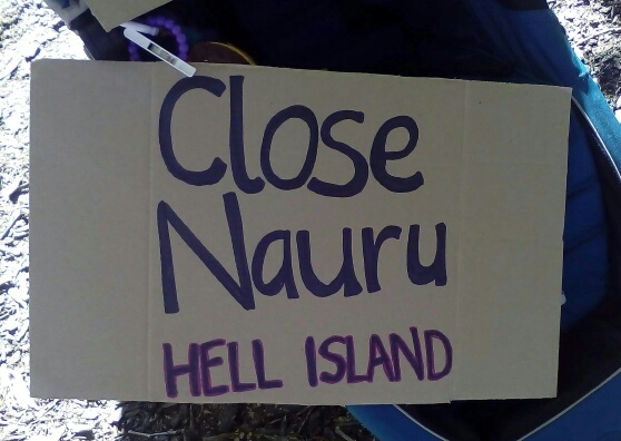 'Close Nauru: hell island', one of three signs written on cardboard and stuck on a stroller, 2015.
